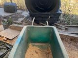 a green wheelbarrow with dirt in the middle of it