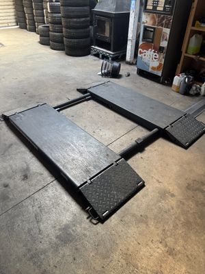 un gros plan sur le sol d'un garage, avec de nombreux pneus en arrière-plan