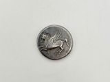a silver coin with a horse on it sitting on top of a table