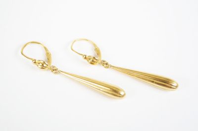 a pair of gold drop earrings on a white background