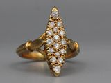 a close up of a gold and diamond ring on a gray surface