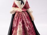 une image représentant une figurine de femme en robe rouge
