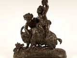 une statue en bronze représentant un garçon et un chien sur un rocher