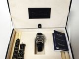 a watch and a pen in a box on a table