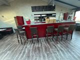 tables and chairs in a restaurant with a red counter and a menu on the wall
