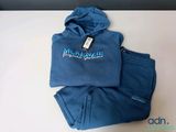 the blue hoodie and pants are on a white table