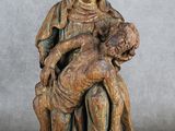 une statue en bois représentant une femme tenant un enfant sur ses genoux