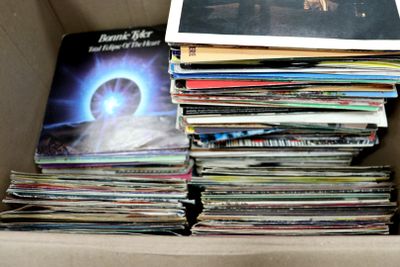 une boîte en carton remplie d'une multitude de disques vinyles