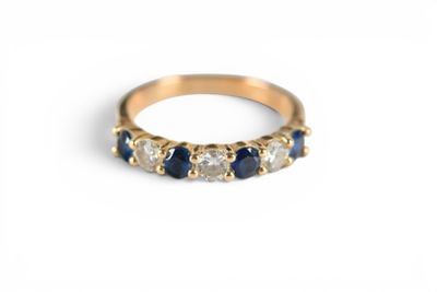 a close up of a gold ring with blue and white stones