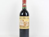 une bouteille de vin rouge posée sur une table blanche