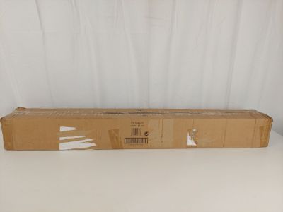 une boîte en carton posée sur une table blanche, avec un rideau blanc en arrière-plan