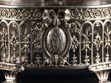 an ornate silver bowl with a cross on the top of it