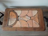 a wooden table with a tile design on top of it