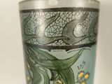 a glass with a design on it sitting on a table
