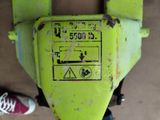 someone standing next to a yellow machine with a red shoe on the ground