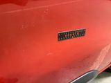 a close up of a red car with a sticker on it