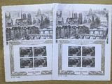 deux pages de timbres posées sur une table, avec une photo d'une ville