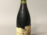 une vieille bouteille de vin posée sur une table blanche