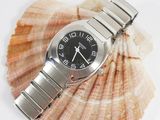 a watch sitting on top of a seashell on a white surface