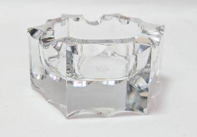 un bougeoir en verre transparent posé sur une surface blanche