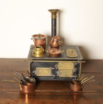un poêle à l'ancienne sur lequel sont posés des casseroles et des poêles
