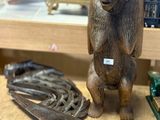 une statue représentant un chat assis sur une étagère, à côté d'autres objets