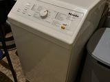 a washing machine and a trash can in a small room
