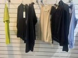 three shirts hanging on a rack in a clothing store