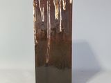 un vase brun posé sur une surface blanche