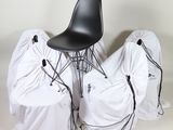 three chairs covered with white covers and a black chair