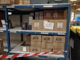 many boxes on a shelf in a store with a red and white ribbon