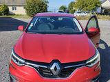 a red car parked in a parking lot next to a house