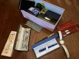 a box of pens, a watch, a wallet, and other items on a table