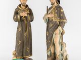 two figurines of a man and a woman with a dog