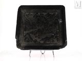 a black tray with a design on it on a stand