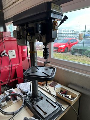 une perceuse posée sur une table devant une fenêtre