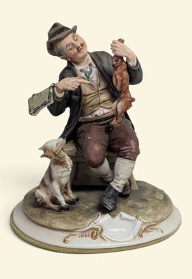 une figurine représentant un homme assis sur un banc avec un chien