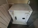 a small white safe box in the corner of a room