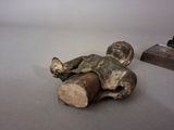 a small statue of a person laying on the ground