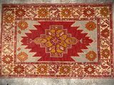 a red and beige rug with a cross design on it