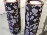 two vases that are sitting on a glass table