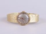 a close up of a gold wrist watch on a white surface