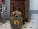 a clock that is sitting on the floor next to a fan