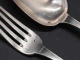 a fork and a spoon on a black table