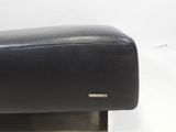 the arm rest of a black leather chair on a white surface