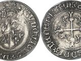 a silver coin with a cross on the front and a lion on the back
