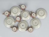 six cups and saucers sitting on a white surface