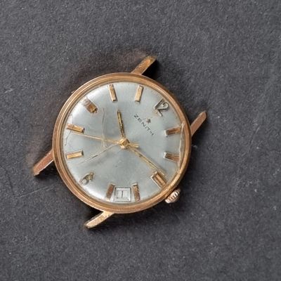 a gold watch with roman numerals on the face
