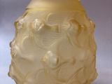 a yellow glass vase with a flower design on it