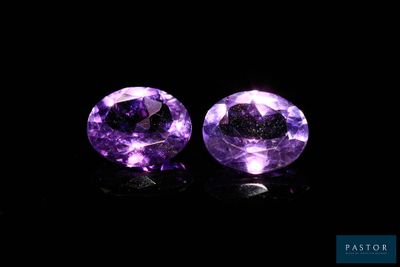 a pair of purple amethtites on a black background